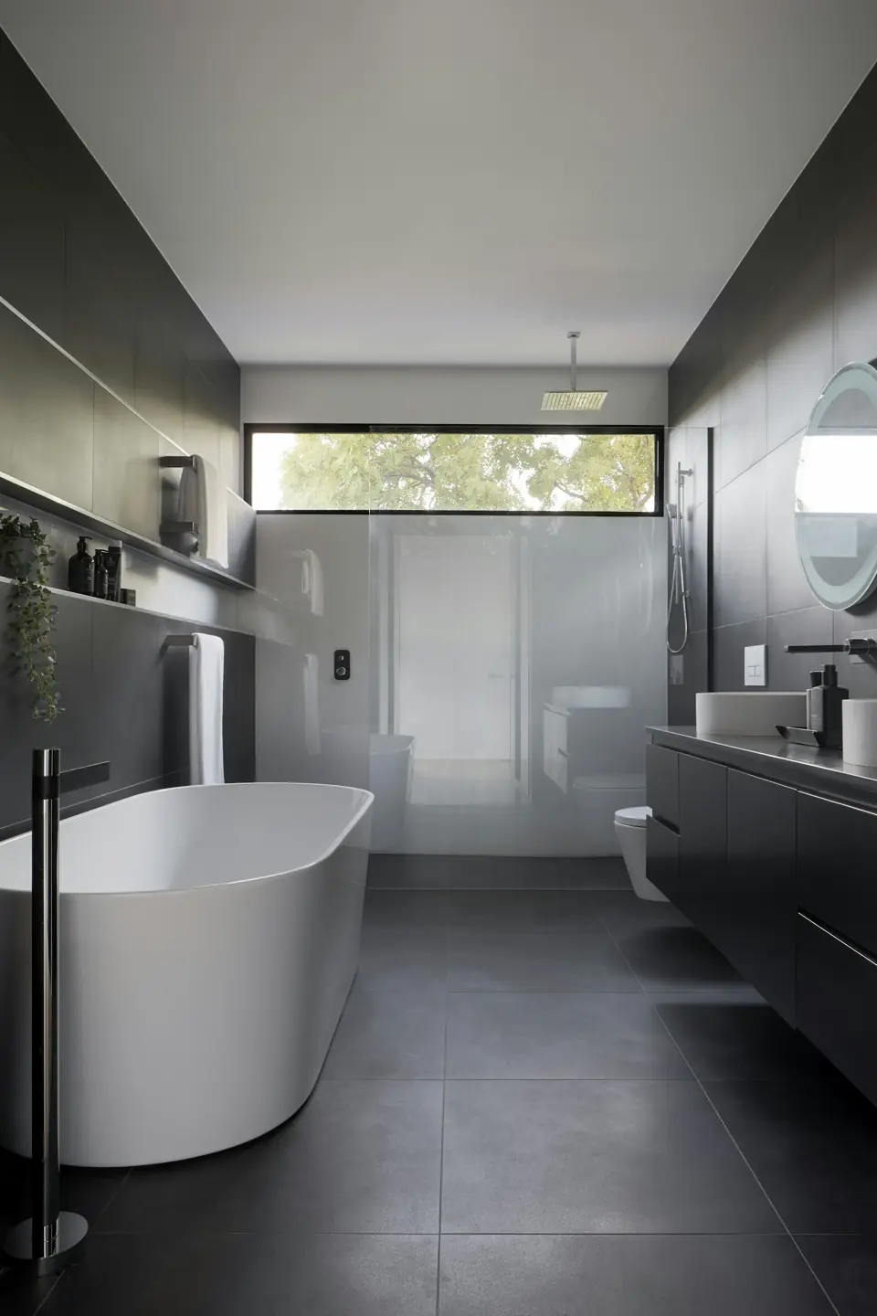 Bathroom with dark floor tile, a freestanding tub and a walk-in shower