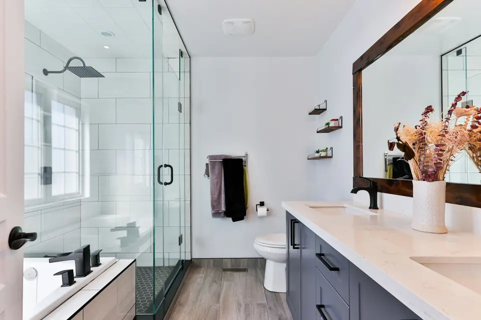 Bathroom with a frameless glass shower, white tile and a long vanity