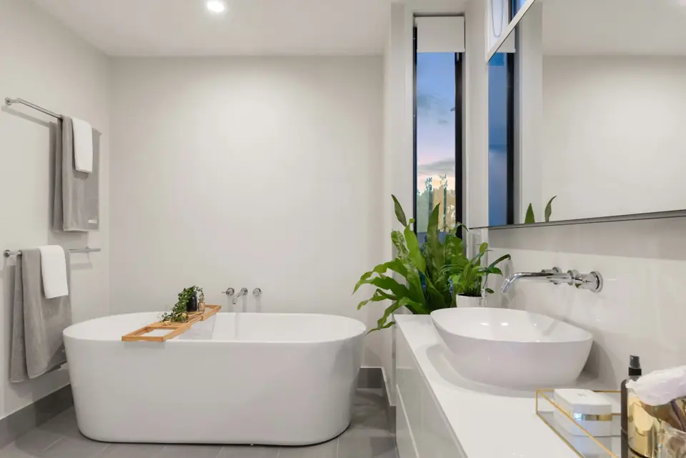 Bathroom with a freestanding white soaking tub and a wall-mounted faucet