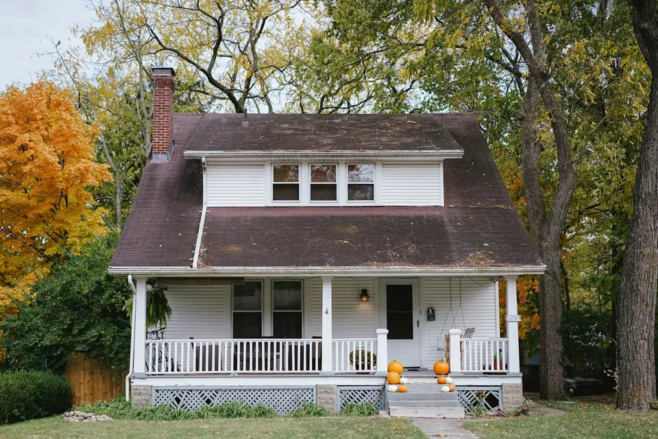 White bungalow with a covered front porch and dark roof