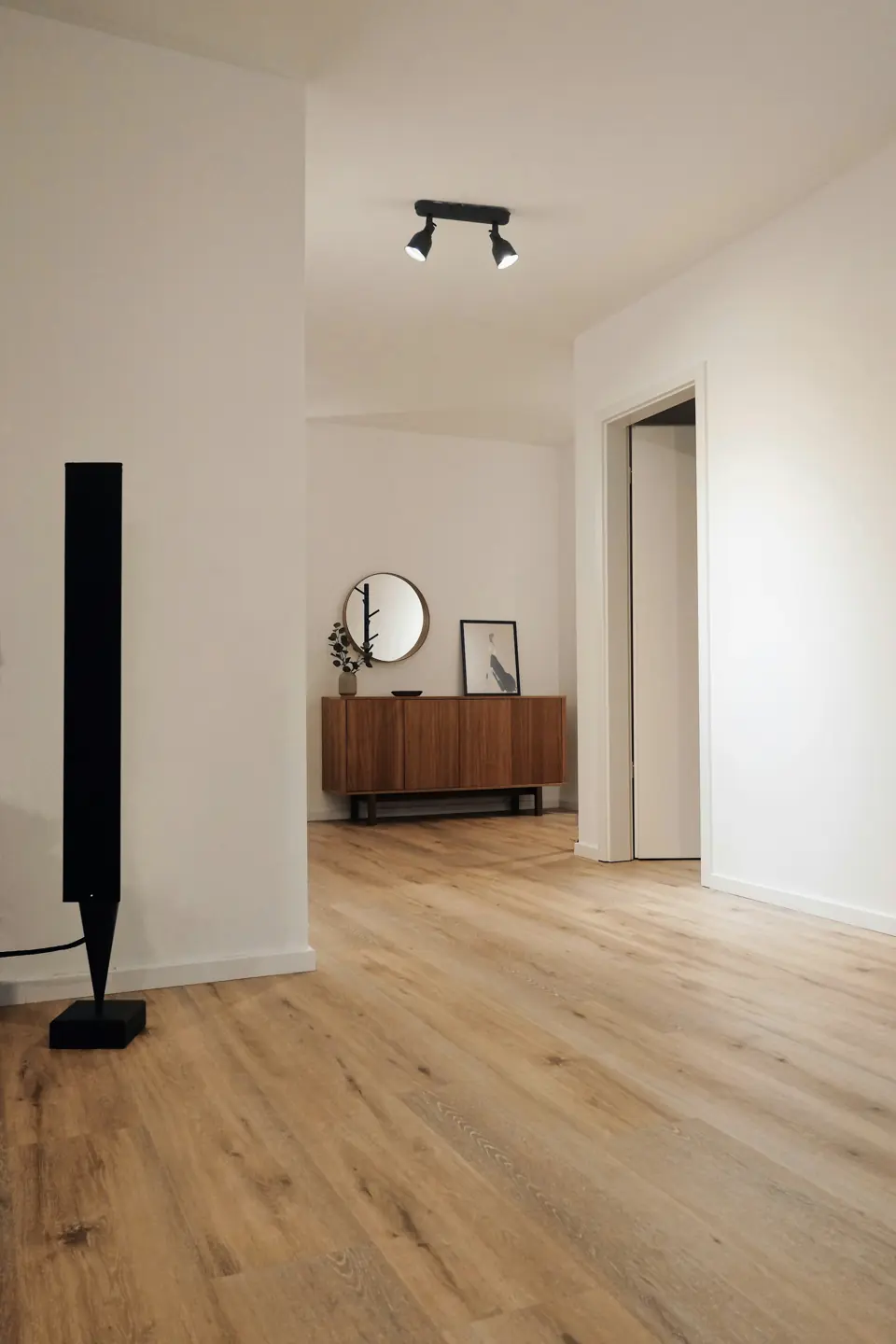Hallway with light oak wood flooring and white walls